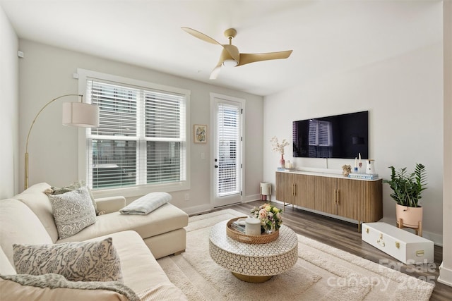 living room featuring dark wood-type flooring and ceiling fan