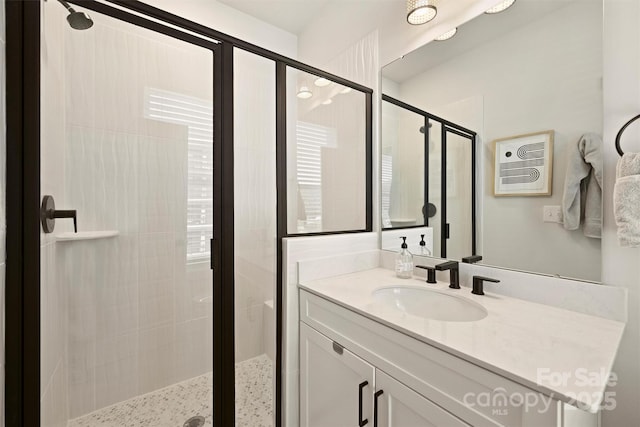 bathroom with vanity and a shower with shower door