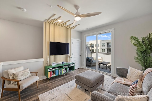 living room with ceiling fan and dark hardwood / wood-style flooring