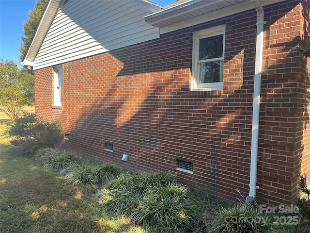 view of property exterior with crawl space and brick siding