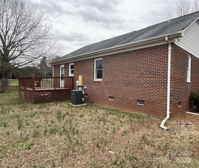 exterior space featuring brick siding, crawl space, a wooden deck, and central air condition unit