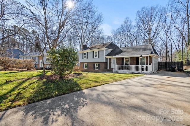 tri-level home featuring a porch and a front yard