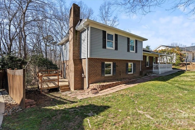 view of side of home with a yard and a deck