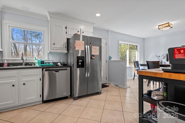 kitchen featuring sink, light tile patterned flooring, white cabinets, and appliances with stainless steel finishes