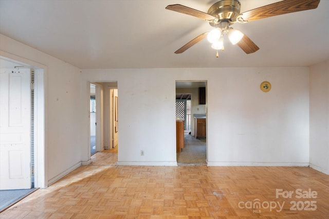 empty room with light parquet flooring and ceiling fan