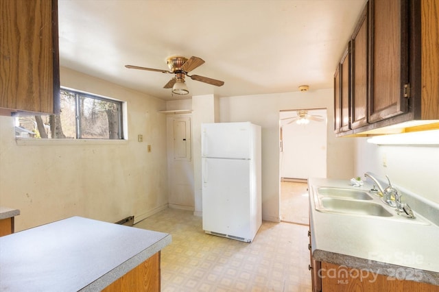 kitchen with white refrigerator, ceiling fan, and sink