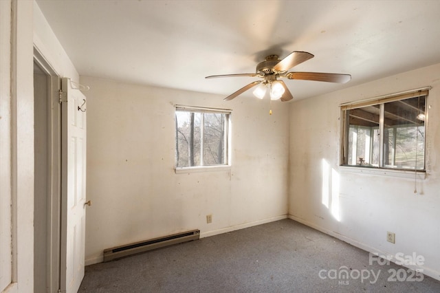 unfurnished room with a baseboard heating unit and ceiling fan