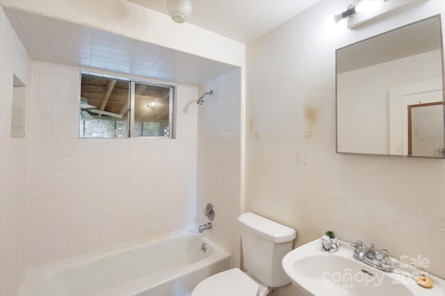 full bathroom with sink, tiled shower / bath combo, and toilet