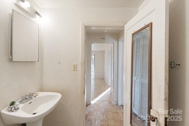 bathroom featuring sink and parquet flooring