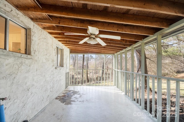 unfurnished sunroom with beam ceiling and ceiling fan