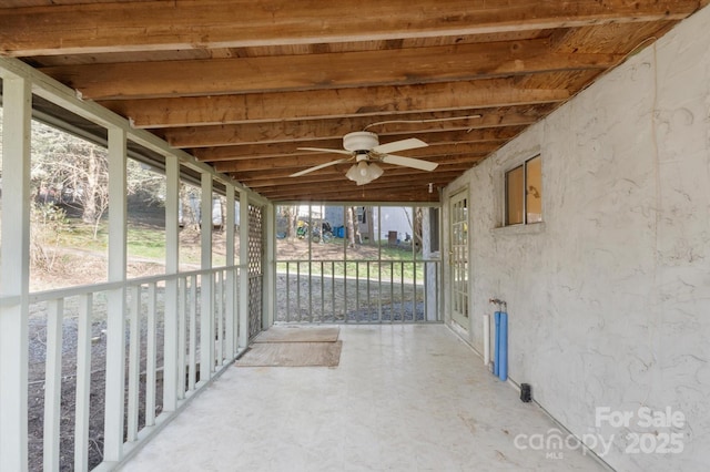 unfurnished sunroom with ceiling fan