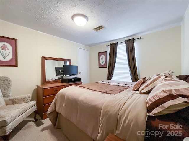 bedroom with light carpet and a textured ceiling