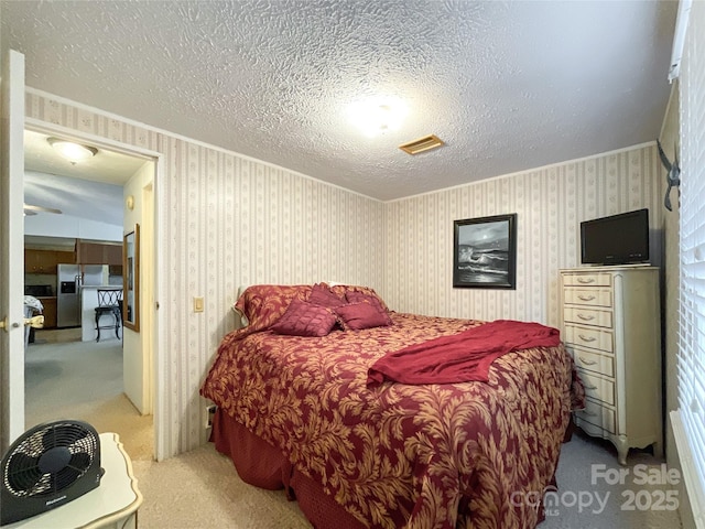 carpeted bedroom with stainless steel refrigerator with ice dispenser and a textured ceiling