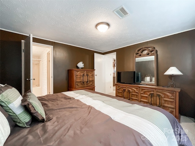 bedroom featuring a textured ceiling and ensuite bathroom