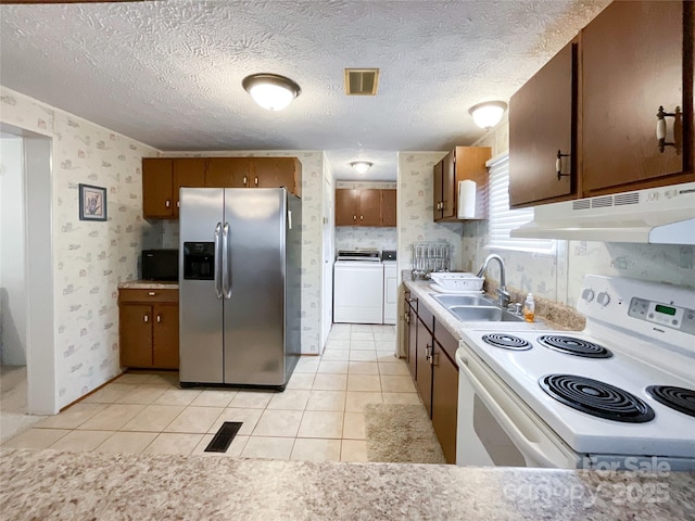 kitchen with sink, white electric range, light tile patterned floors, washer and dryer, and stainless steel fridge with ice dispenser