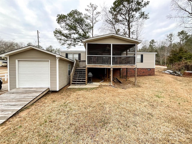 back of house featuring a garage, a yard, and a sunroom