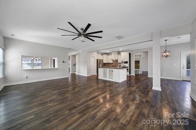 unfurnished living room featuring dark wood-type flooring and ceiling fan