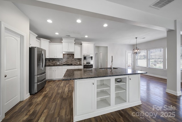 kitchen featuring white cabinetry, sink, stainless steel appliances, and an island with sink