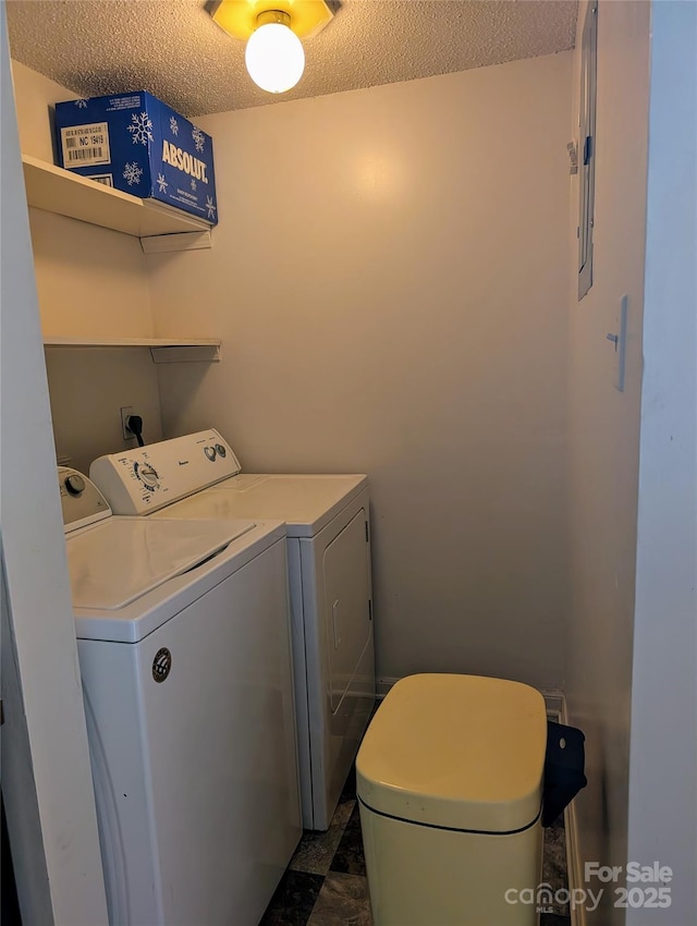 washroom featuring a textured ceiling and washer and clothes dryer