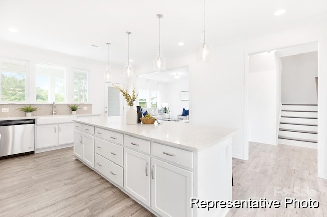 kitchen featuring white cabinetry, sink, hanging light fixtures, a center island, and stainless steel dishwasher