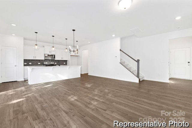 110 Shay Crossing Rd Unit 1P, Salisbury, NC 28144 - unfurnished living room featuring dark wood-style flooring, stairs, and recessed lighting