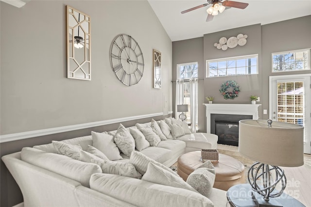 living room with wood-type flooring, high vaulted ceiling, and ceiling fan