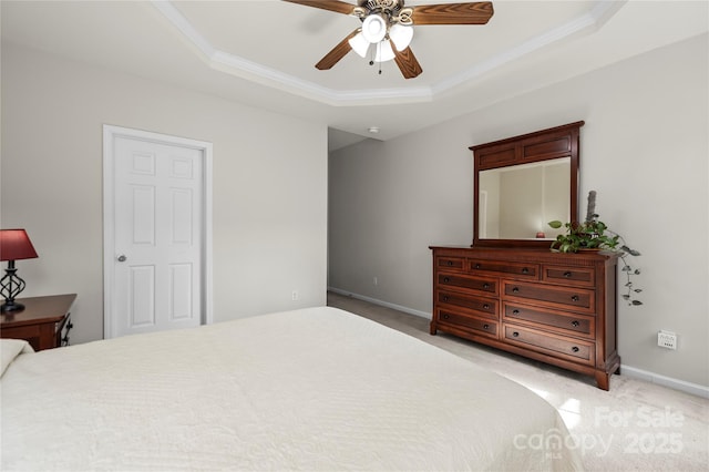 carpeted bedroom featuring crown molding, a raised ceiling, and ceiling fan