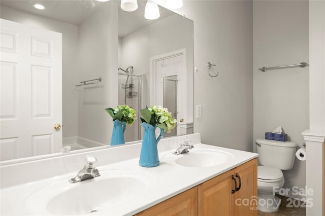 bathroom featuring vanity, toilet, and a shower with door