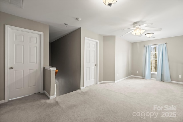 empty room featuring ceiling fan and light carpet