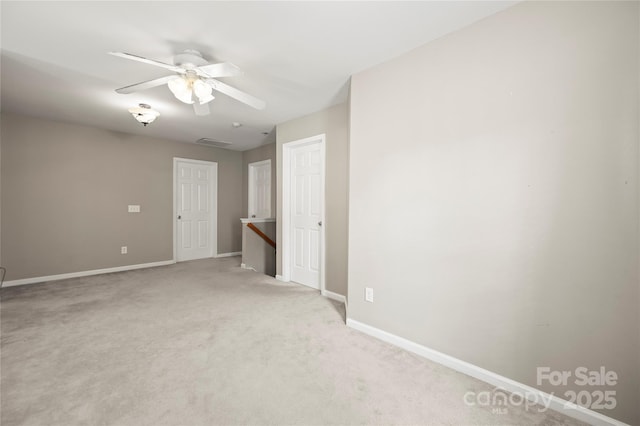 carpeted spare room featuring ceiling fan