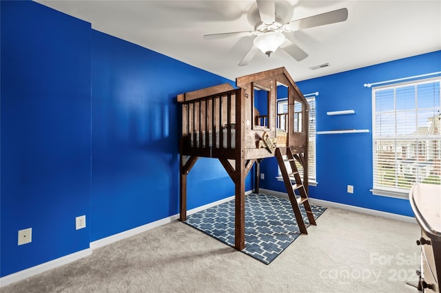 unfurnished bedroom with ceiling fan, carpet flooring, and multiple windows