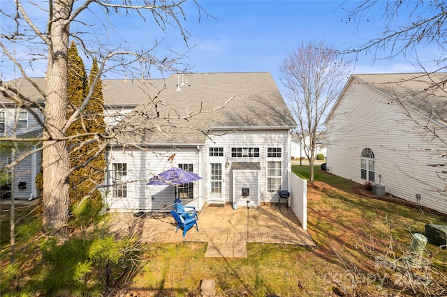 back of house with a patio and a lawn