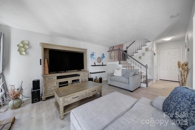 living room with light wood-type flooring and a textured ceiling