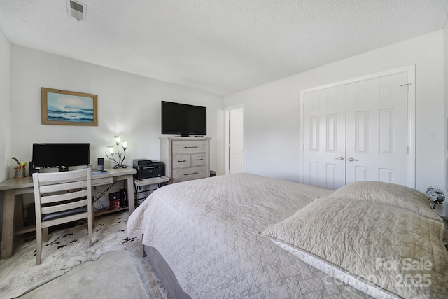 bedroom with a textured ceiling and a closet