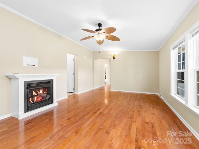 449 Riverwind Dr, Hendersonville, NC 28739 - unfurnished living room featuring light wood-style flooring, crown molding, a glass covered fireplace, and ceiling fan