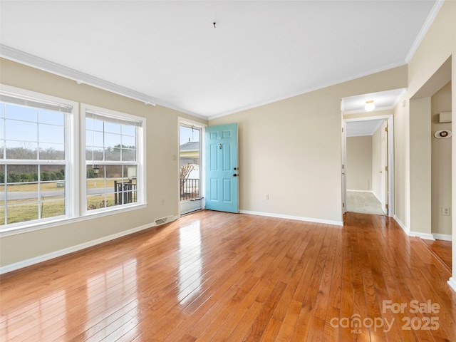 449 Riverwind Dr, Hendersonville, NC 28739 - unfurnished living room with crown molding, baseboards, light wood finished floors, and visible vents