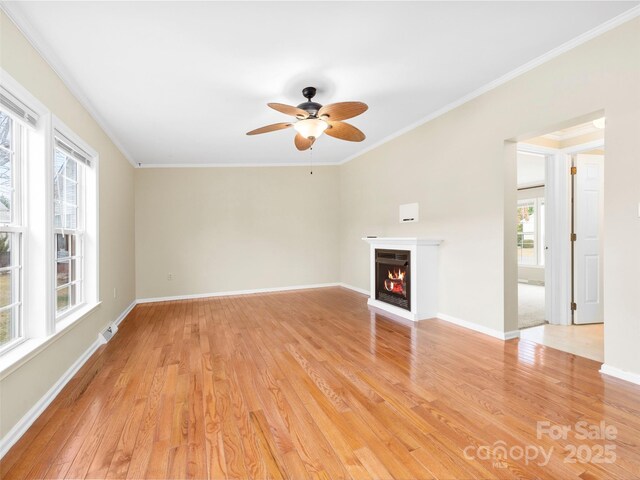 449 Riverwind Dr, Hendersonville, NC 28739 - unfurnished living room featuring a warm lit fireplace, light wood-type flooring, crown molding, and a ceiling fan