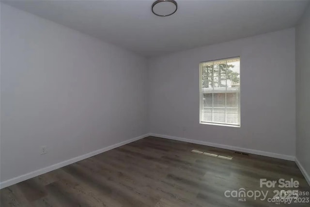 spare room with dark hardwood / wood-style flooring