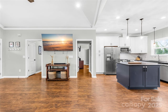 kitchen with crown molding, stainless steel appliances, hanging light fixtures, and white cabinets