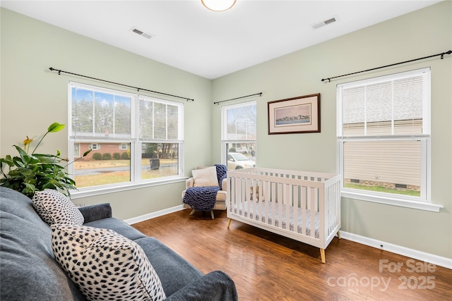 bedroom featuring dark hardwood / wood-style flooring and multiple windows