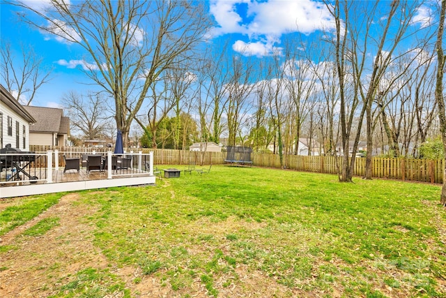 view of yard featuring a wooden deck and a trampoline