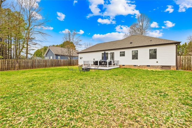 back of property featuring a wooden deck and a yard