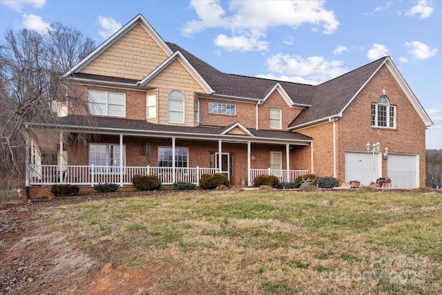 view of front of home with a garage, a front lawn, and covered porch