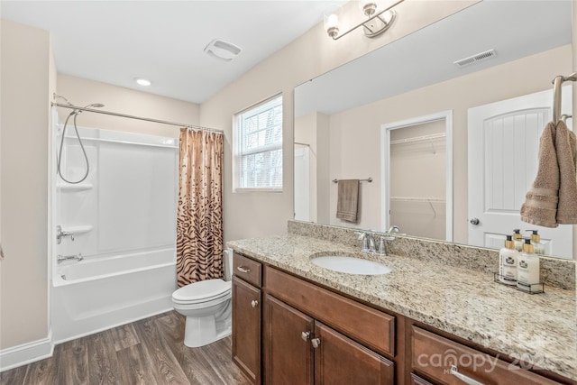 full bathroom featuring wood-type flooring, shower / tub combo with curtain, vanity, and toilet