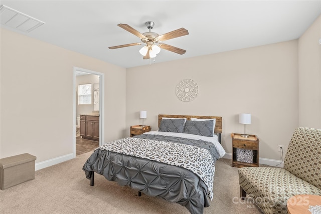 bedroom featuring visible vents, ceiling fan, baseboards, carpet floors, and ensuite bathroom