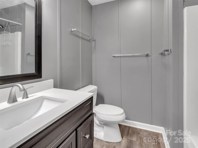 bathroom with vanity, toilet, and hardwood / wood-style floors