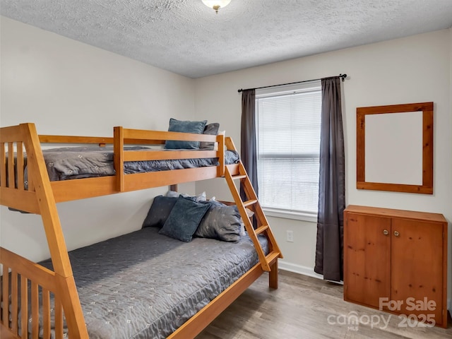 bedroom featuring hardwood / wood-style flooring and a textured ceiling