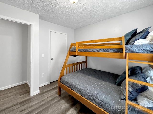 bedroom featuring dark wood-type flooring and a textured ceiling