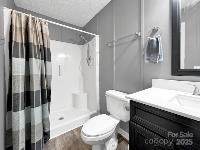 bathroom with hardwood / wood-style floors, vanity, toilet, a textured ceiling, and a shower with curtain