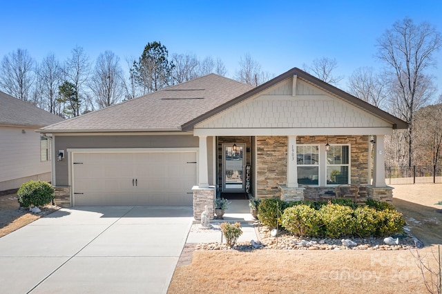 craftsman house with stone siding, roof with shingles, driveway, and an attached garage